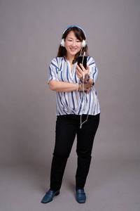 带耳机的日本成熟女商人的肖像