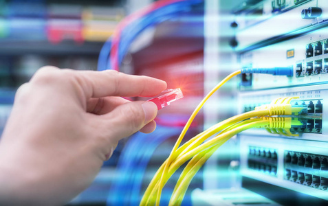 在网络服务器机房工作的人,配备数字通信和互联网的光纤集线器照片