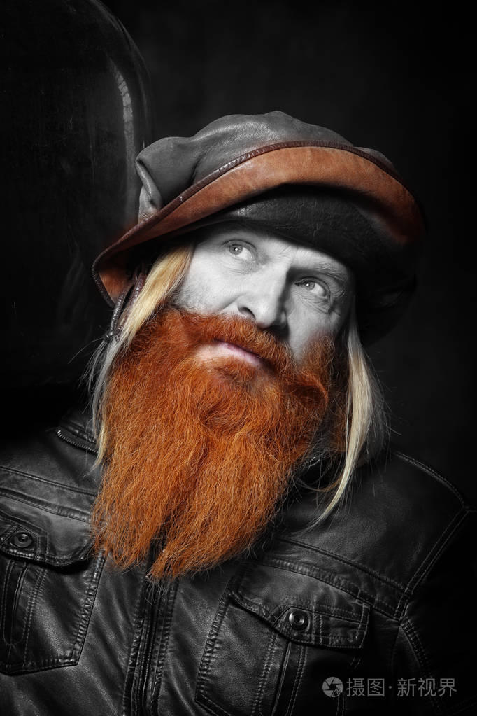 一位留着红色胡子留着瓶子的成年男子的肖像背景是深色的