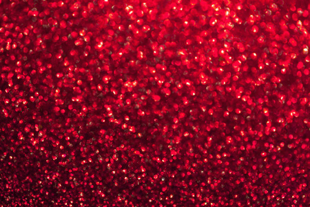 模糊的红色背景与圆圈闪闪发光。 闪亮灿烂的圣诞花环。 深色葡萄酒背景
