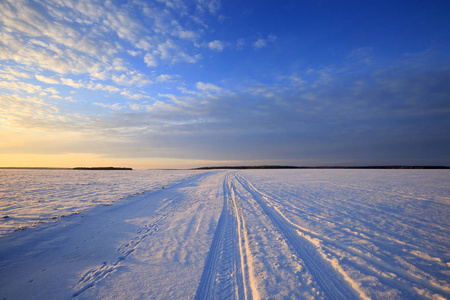 冬天的风景雪覆盖着田野和道路，阳光照耀着夕阳