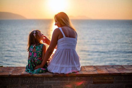 母亲和女儿在海上享受日落