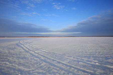 冬天的风景雪覆盖着田野和道路，阳光照耀着夕阳