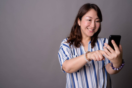 成熟美丽的亚洲女商人使用手机