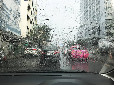 透过车窗看路，雨滴在雨中行驶