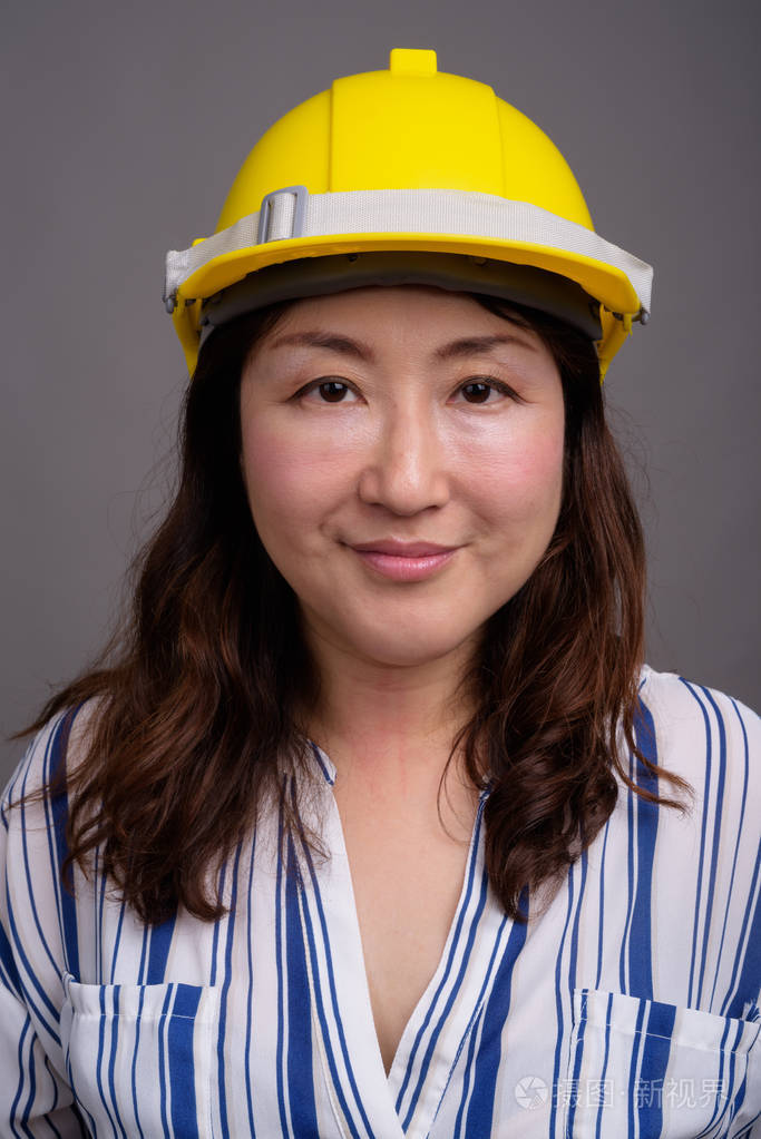 穿着安全帽的成熟亚洲女商人建筑工人