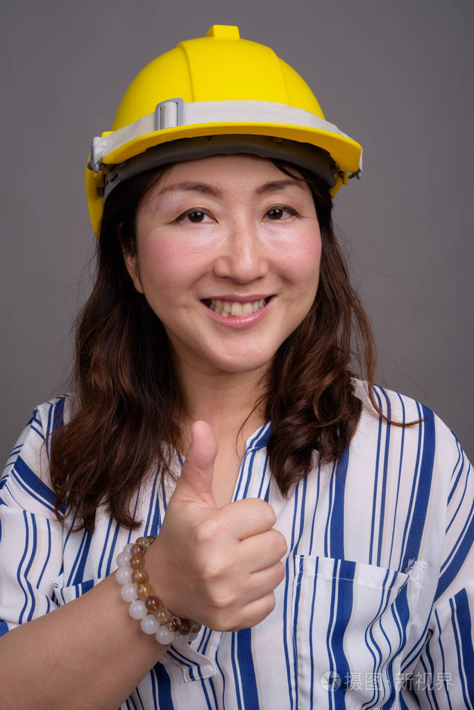 穿着安全帽的成熟亚洲女商人建筑工人