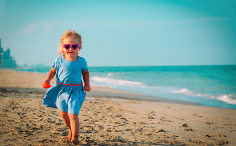 快乐可爱的小女孩跑在海滩上玩