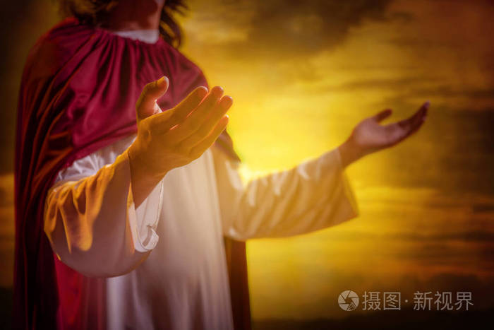 耶稣基督举手祈祷日落背景