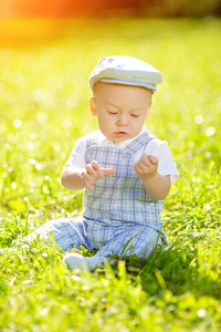 草地上公园里可爱的小宝宝。 可爱的户外宝宝。 微笑的情感孩子