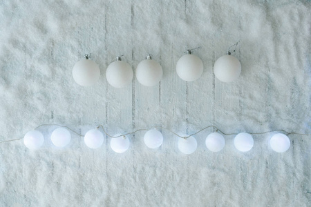 白色木制桌子背景，带雪和灯球装饰，圣诞概念，顶景