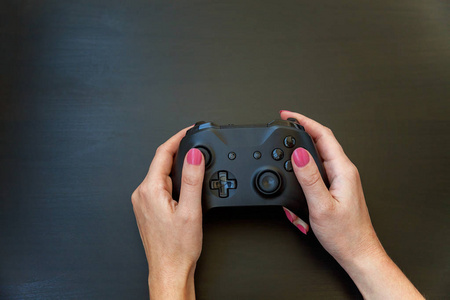 女人手拿黑色操纵杆游戏垫游戏控制台在黑色背景。 电脑游戏竞争视频控制对抗概念