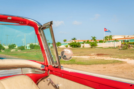 古巴瓦拉迪罗在一辆古老的老式经典美国汽车的视野中，右边是古巴国旗的一天。
