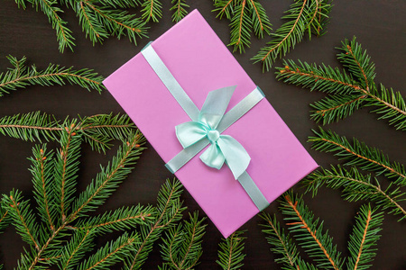 圣诞节新年作文冬季物品冷杉枝和礼品盒上的黑色木制背景。 圣诞节假期十二月装饰。 平躺顶部视图复制空间。 庆祝概念的时间