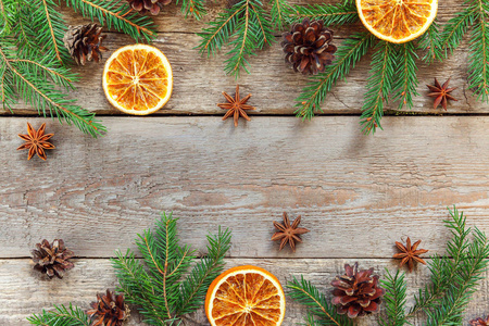 圣诞节新年构图框架与冷杉枝松果橙色切片上的旧破旧乡村木制背景。 圣诞节假期十二月装饰。 平躺复制空间时间庆祝概念