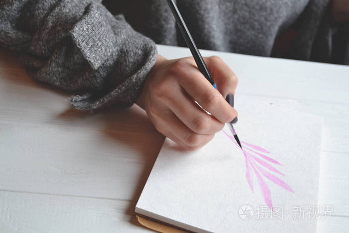 女人在素描本上画画在白色的木桌上画画的工具画家的作品