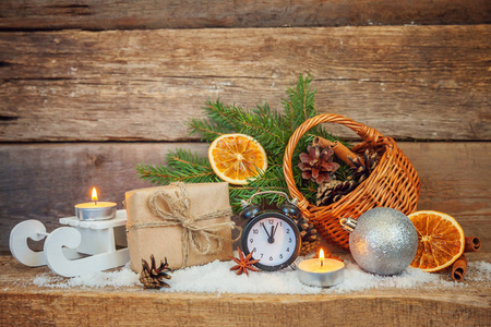 圣诞节新年作文冬季物品礼品盒冷杉支篮松果球雪橇蜡烛闹钟在破旧的乡村木制背景。 圣诞假期十二月装饰复制品