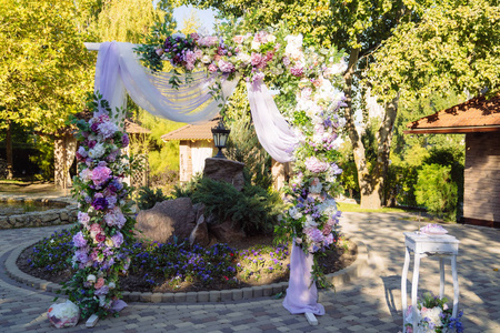 婚礼当天, 新郎新娘的仪式地点, 装饰, 鲜花。装饰的概念, 婚礼拱形装饰有鲜花粉红色和白色牡丹