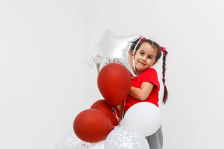 快乐的小女孩带着一堆五颜六色的气球