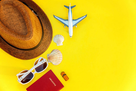 平躺着帽子，飞机，护照，太阳镜和贝壳，黄色，五颜六色，时尚的现代时尚背景。 度假旅行暑假周末海上冒险旅行概念