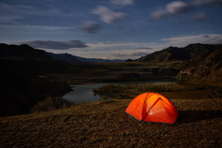 帐篷和露营山景观的夜间河流和山脉。