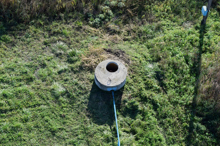 带有潜水泵的自流井. 上面盖着混凝土井照片