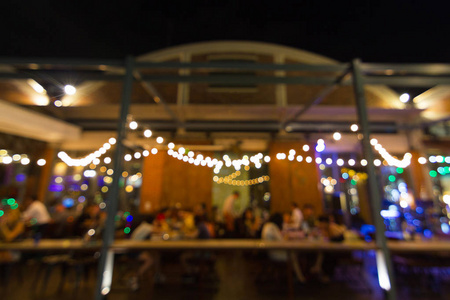 抽象模糊的形象夜间节日在餐厅和气氛是快乐和放松与Bokeh为背景。