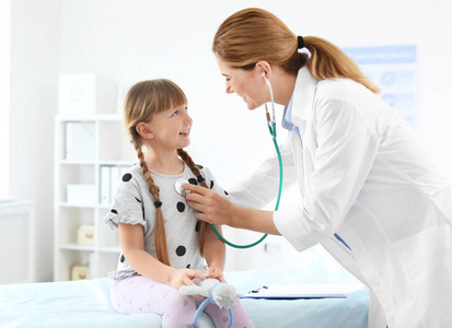 s doctor examining little girl in hospital