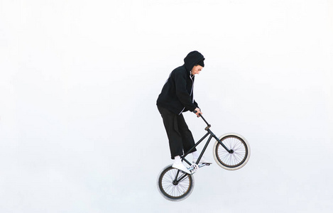 骑自行车的人在白色背景上骑自行车跳跃。在白色背景上隔离的BMX上的骑手跳跃。宇宙空间。Bmx概念