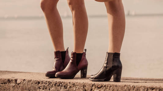 两个不可辨认的时尚女性穿着时尚的户外鞋。适合秋冬季节的靴子