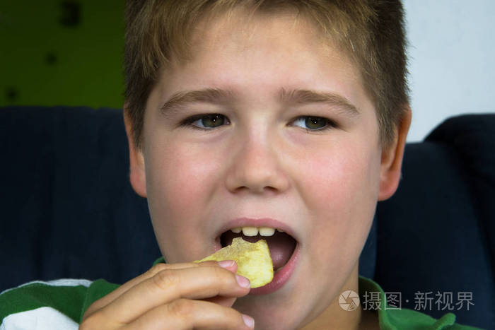 肥胖的小男孩在吃薯片