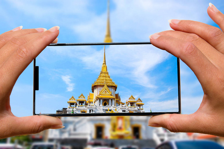 女人用手机拍照寺庙参观泰国。