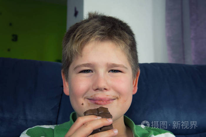 肥胖的小男孩在吃巧克力