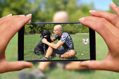 女人带手机照片男人带狗。