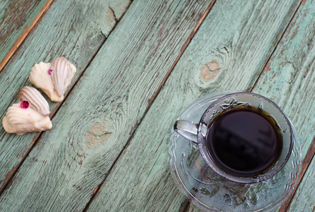 在旧的绿松石木板上放饼干的咖啡杯