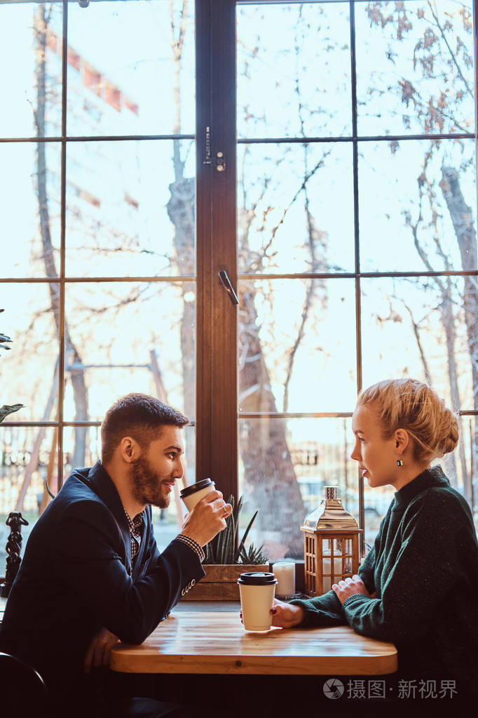 浪漫的情侣在咖啡馆里喝咖啡和交谈