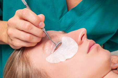 睫毛护理治疗程序。 女人做睫毛分层染色卷曲层压和延长睫毛。