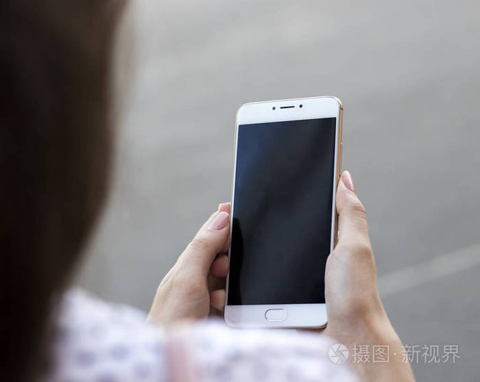 女孩手里拿着智能手机社交网络在日常生活中工作在智能手机上