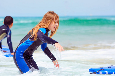穿蓝色衣服的十几岁女孩学习冲浪。