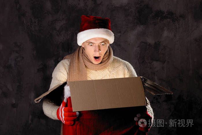 圣诞礼物概念戴圣诞帽的人给你带礼物有魅力的男人拿着盒子圣诞节和