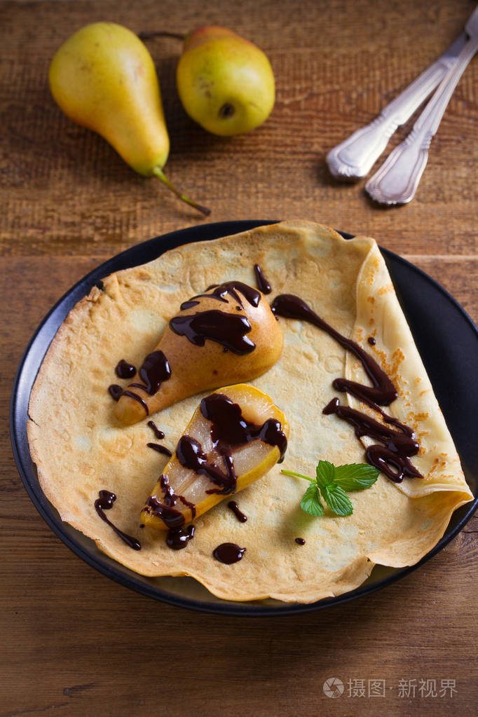 烤梨和巧克力的奶油饼. 薄煎饼,烤梨和巧克力. 垂直垂直垂直