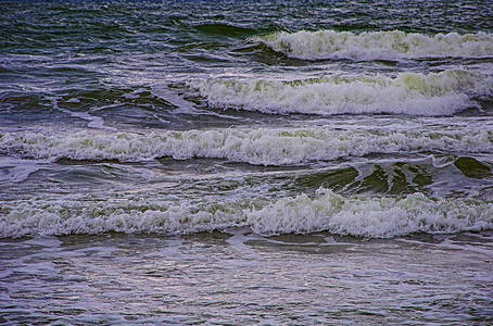 黑海的波浪。 海洋背景。 带泡沫的绿色急流。 多云天气下的海景。 艺术质感摄影。