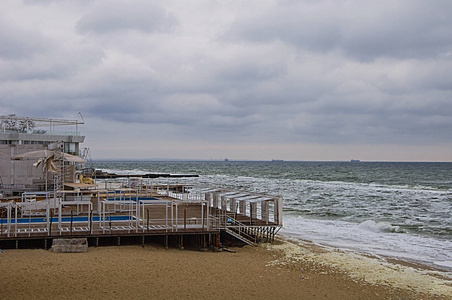 海景。 蓝天和绿色的波浪背景。 在远处的蒸汽机里。 海滩上的封闭建筑。 旅游季节的结束。 艺术质感摄影。