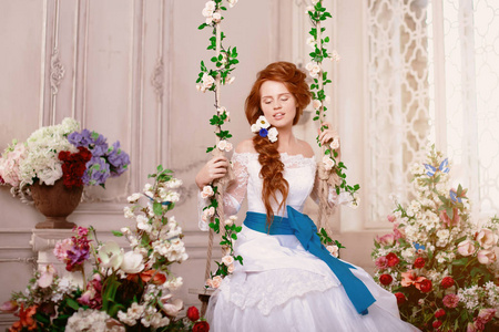 美丽的女孩模特公主在宫殿里戴着花。 新娘穿着白色连衣裙。 穿着豪华复古内饰的女人。