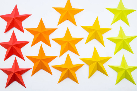 儿童星空一颗由红橙黄颜色的纸制成的星星.节日装饰星空.白色背景.