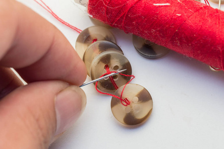 针与线和按钮隔离在白色，针线和裁剪概念缝纫按钮，针和针。