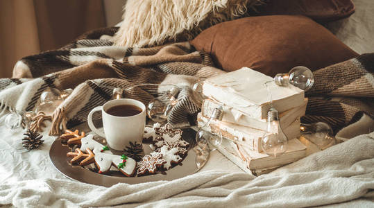 杯子与茶或咖啡, 冷杉树枝, 雪花形状的饼干, 舒适的针织毯子, 棉花和舒适的花环, 新年