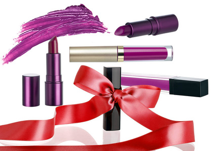 安排口红化妆品作为节日礼品。 这些产品有丝带或蝴蝶结，以显示他们是在季节性圣诞节销售。 孤立在白色背景上。