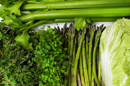 背景有很多新鲜的绿色不同的蔬菜和草药，顶部的视野特写。 健康合理营养饮食排毒理念西兰芹菜芽菜芦笋