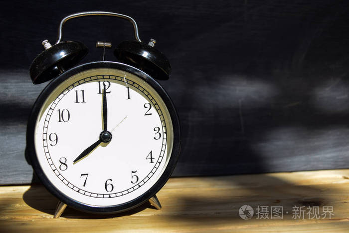 上午8点/下午8点回到学校概念. 木制闹钟,背景黑板